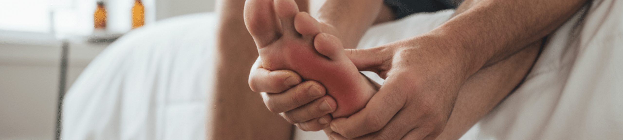 Patient se massant le pied en raison d’une douleur de l’avant-pied.