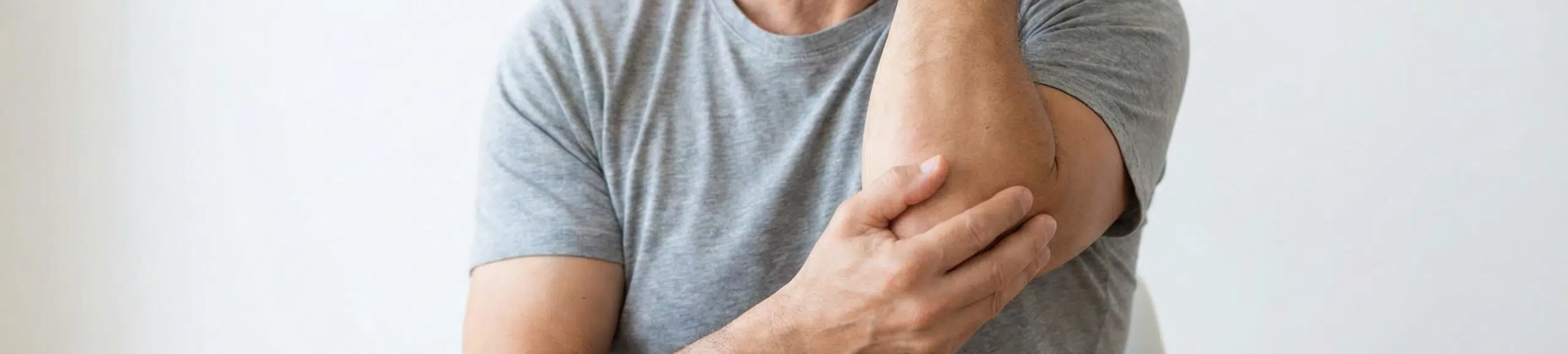Homme présentant une douleur au coude pouvant évoquer une tendinopathie ou une arthrose