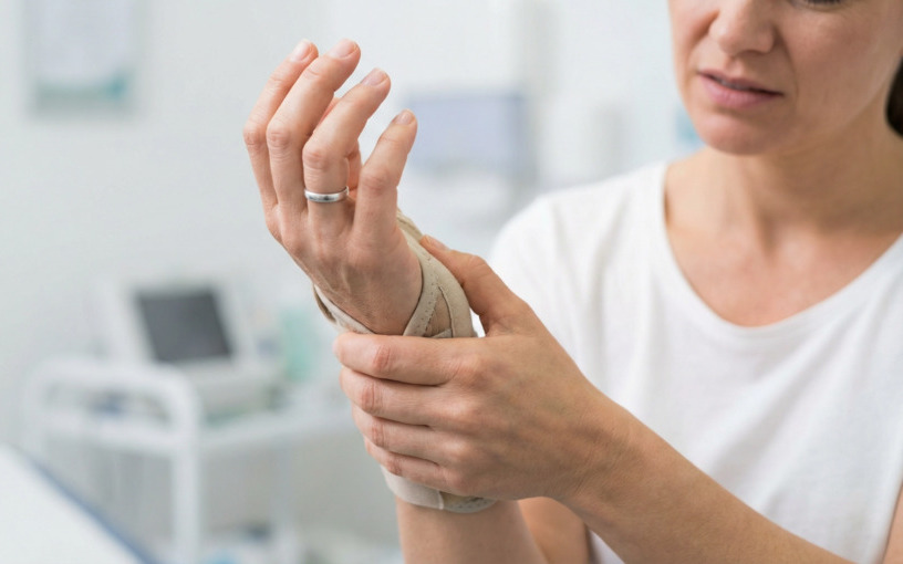 Femme portant une attelle de poignet pour soulager une douleur du canal carpien